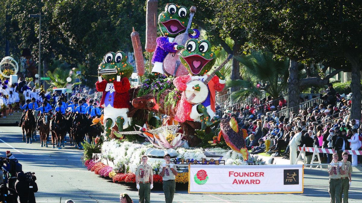 A picture of Tree Frog Night on the parade route with the accompanying Founder Trophy banner being carried in front